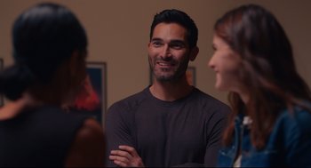 Movie still from “Can You Keep a Secret?” (2019), directed by Elise Durán – A man standing next to two women in a room; Medium shot, Over the shoulder angle