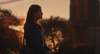 Movie still from “Can You Keep a Secret?” (2019), directed by Elise Durán – A woman standing in front of a tree at sunset; Medium shot, Over the shoulder angle