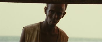 Movie still from “Captain Phillips” (2013), directed by Paul Greengrass – A man's face looking at the camera; Close Up shot, Low angle