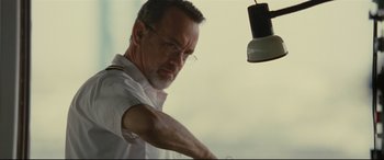 Movie still from “Captain Phillips” (2013), directed by Paul Greengrass – A man in a white dress shirt and glasses; Close Up shot, Low angle