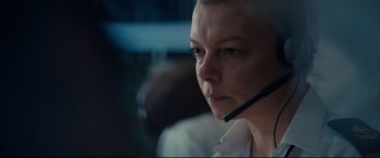 Movie still from “Captain Phillips” (2013), directed by Paul Greengrass – A woman with a headset on looking into the distance; Close Up shot, Over the shoulder angle