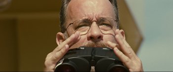 Movie still from “Captain Phillips” (2013), directed by Paul Greengrass – A person wearing glasses looking through binoculars; Close Up shot, Low angle