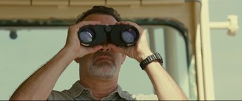 Movie still from “Captain Phillips” (2013), directed by Paul Greengrass – A man looking through a pair of binoculars; Close Up shot, Low angle