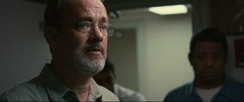 Movie still from “Captain Phillips” (2013), directed by Paul Greengrass – An older man wearing glasses and a white shirt; Close Up shot, Over the shoulder angle