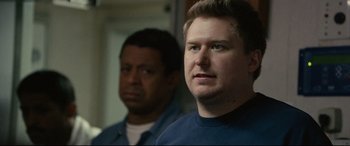 Movie still from “Captain Phillips” (2013), directed by Paul Greengrass – A man standing next to another man in front of a mirror; Close Up shot, Over the shoulder angle