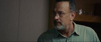 Movie still from “Captain Phillips” (2013), directed by Paul Greengrass – An older man wearing glasses and a green shirt; Close Up shot, Over the shoulder angle