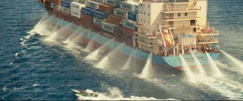 Movie still from “Captain Phillips” (2013), directed by Paul Greengrass – A boat is in the water near a large ship; Extreme Wide shot, High angle