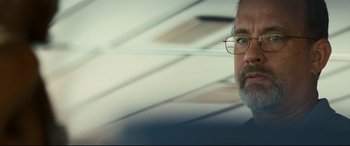 Movie still from “Captain Phillips” (2013), directed by Paul Greengrass – A person wearing glasses and a beard; Close Up shot, Over the shoulder angle