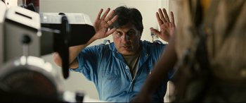Movie still from “Captain Phillips” (2013), directed by Paul Greengrass – A man in a blue shirt is looking at himself in the mirror; Close Up shot, Over the shoulder angle