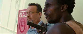 Movie still from “Captain Phillips” (2013), directed by Paul Greengrass – A man holding a gun next to another man; Close Up shot, Over the shoulder angle