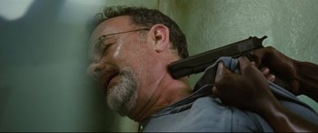 Movie still from “Captain Phillips” (2013), directed by Paul Greengrass – A person holding a gun over their head; Close Up shot, Low angle