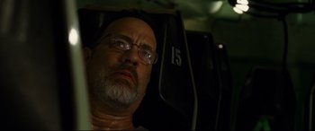 Movie still from “Captain Phillips” (2013), directed by Paul Greengrass – An older man with glasses is sitting in a car; Close Up shot, Overhead angle