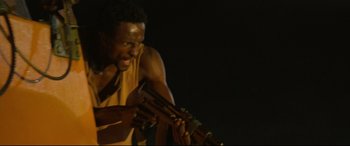 Movie still from “Captain Phillips” (2013), directed by Paul Greengrass – A man holding a guitar in his hands; Close Up shot, Low angle