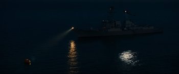 Movie still from “Captain Phillips” (2013), directed by Paul Greengrass – A boat in the water at night with a light shining on it; Extreme Wide shot, High angle