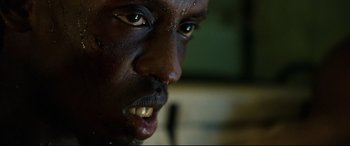 Movie still from “Captain Phillips” (2013), directed by Paul Greengrass – A man's face with a very sharp teeth; Extreme Close Up shot, Low angle