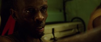 Movie still from “Captain Phillips” (2013), directed by Paul Greengrass – A person with a beard looking at the camera; Close Up shot, Low angle