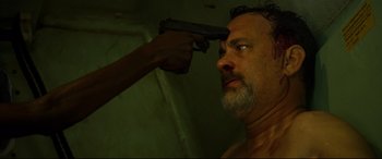 Movie still from “Captain Phillips” (2013), directed by Paul Greengrass – A man is holding a gun up to his face; Close Up shot, High angle