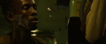 Movie still from “Captain Phillips” (2013), directed by Paul Greengrass – A person in front of a punching bag; Close Up shot, Low angle