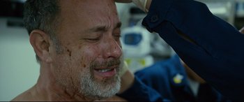 Movie still from “Captain Phillips” (2013), directed by Paul Greengrass – An older man with a bandage on his face; Close Up shot, Overhead angle