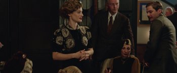 Movie still from “The Zookeeper's Wife” (2017), directed by Niki Caro – A woman standing in front of a group of people; Medium shot, Over the shoulder angle