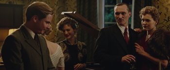 Movie still from “The Zookeeper's Wife” (2017), directed by Niki Caro – A group of people standing next to each other in a room; Medium shot, Over the shoulder angle