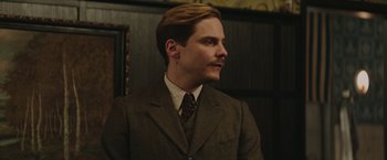 Movie still from “The Zookeeper's Wife” (2017), directed by Niki Caro – A man wearing a suit and tie in front of a wooden wall; Close Up shot, Low angle