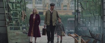 Movie still from “The Zookeeper's Wife” (2017), directed by Niki Caro – A man , woman , and child walking down a street; Wide shot, Low angle
