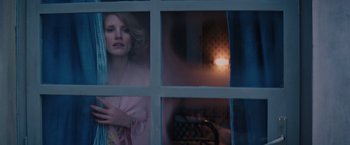 Movie still from “The Zookeeper's Wife” (2017), directed by Niki Caro – A woman looking out of a window at night; Medium shot, Over the shoulder angle