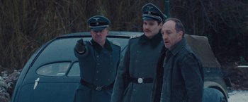 Movie still from “The Zookeeper's Wife” (2017), directed by Niki Caro – A group of men standing next to each other in uniforms; Medium shot, Over the shoulder angle