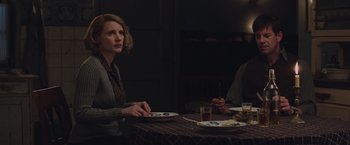 Movie still from “The Zookeeper's Wife” (2017), directed by Niki Caro – A woman sitting at a table with a plate in front of a man; Medium shot, Over the shoulder angle