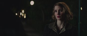 Movie still from “The Zookeeper's Wife” (2017), directed by Niki Caro – A woman in a black coat standing in the dark at night; Close Up shot, Over the shoulder angle