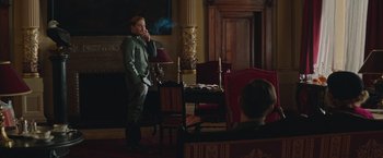 Movie still from “The Zookeeper's Wife” (2017), directed by Niki Caro – A man standing next to a table in a room; Wide shot, Over the shoulder angle
