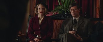 Movie still from “The Zookeeper's Wife” (2017), directed by Niki Caro – A woman and a man sitting next to each other on a couch; Medium shot, Low angle