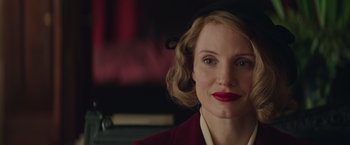 Movie still from “The Zookeeper's Wife” (2017), directed by Niki Caro – A person wearing a hat and lipstick; Close Up shot, Over the shoulder angle