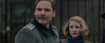Movie still from “The Zookeeper's Wife” (2017), directed by Niki Caro – A man in a military uniform and a woman in a green scarf; Close Up shot, Low angle