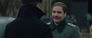 Movie still from “The Zookeeper's Wife” (2017), directed by Niki Caro – A man in a green coat talking to another man in a black coat; Close Up shot, Over the shoulder angle