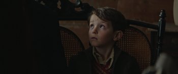 Movie still from “The Zookeeper's Wife” (2017), directed by Niki Caro – A young boy sitting in a chair looking up; Close Up shot, Low angle