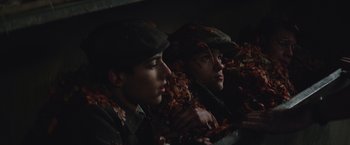 Movie still from “The Zookeeper's Wife” (2017), directed by Niki Caro – A couple of people that are sitting in the leaves; Close Up shot, High angle