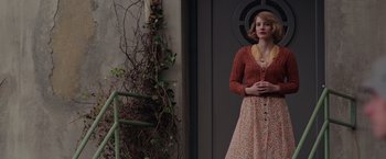 Movie still from “The Zookeeper's Wife” (2017), directed by Niki Caro – A woman standing in front of a building with plants growing; Medium shot, Over the shoulder angle