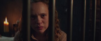 Movie still from “The Zookeeper's Wife” (2017), directed by Niki Caro – A woman with curly brown hair is behind bars; Close Up shot, Over the shoulder angle