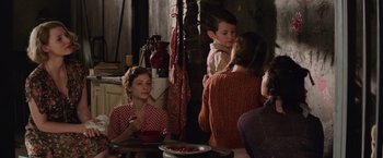 Movie still from “The Zookeeper's Wife” (2017), directed by Niki Caro – A group of people sitting around a table; Medium shot, Over the shoulder angle