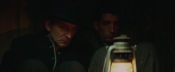 Movie still from “The Zookeeper's Wife” (2017), directed by Niki Caro – Two men sitting next to each other in the dark; Close Up shot, Low angle