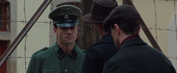Movie still from “The Zookeeper's Wife” (2017), directed by Niki Caro – A man in a military uniform is looking at a man in a hat; Close Up shot, Over the shoulder angle