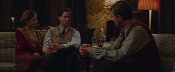 Movie still from “The Zookeeper's Wife” (2017), directed by Niki Caro – Two men are sitting at a table with wine glasses; Medium shot, Over the shoulder angle