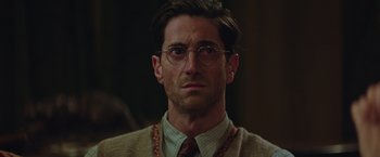 Movie still from “The Zookeeper's Wife” (2017), directed by Niki Caro – A person wearing glasses and a sweater; Close Up shot, Low angle