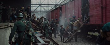 Movie still from “The Zookeeper's Wife” (2017), directed by Niki Caro – A group of people standing next to each other on a street; Wide shot, High angle