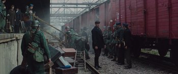Movie still from “The Zookeeper's Wife” (2017), directed by Niki Caro – A group of men standing next to each other on train tracks; Wide shot, Low angle
