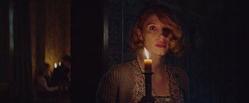 Movie still from “The Zookeeper's Wife” (2017), directed by Niki Caro – A woman holding a lit candle in a dark room; Close Up shot, Low angle