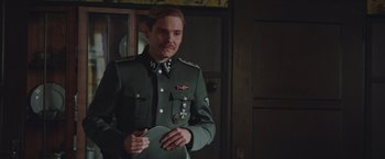 Movie still from “The Zookeeper's Wife” (2017), directed by Niki Caro – A man in a military uniform holding a plate; Medium shot, Over the shoulder angle
