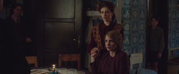Movie still from “The Zookeeper's Wife” (2017), directed by Niki Caro – Two women sitting at a table with a lit candle; Medium shot, Over the shoulder angle